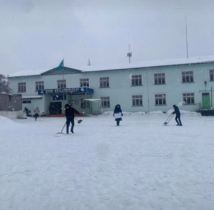 Мектеп оқушылары, мектеп ауласын қардан тазалауда